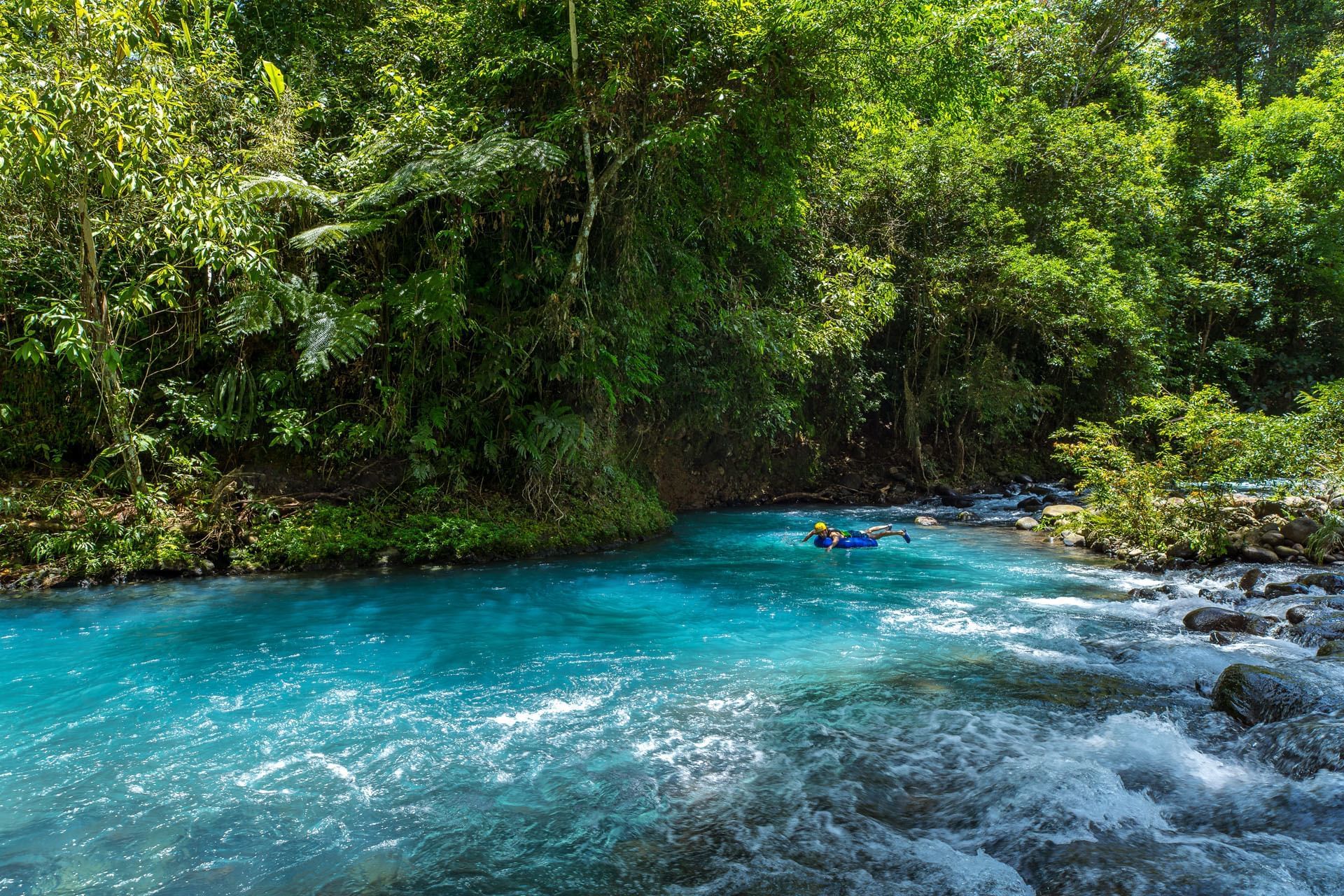 Turista observando el color celeste del río desde un mirador